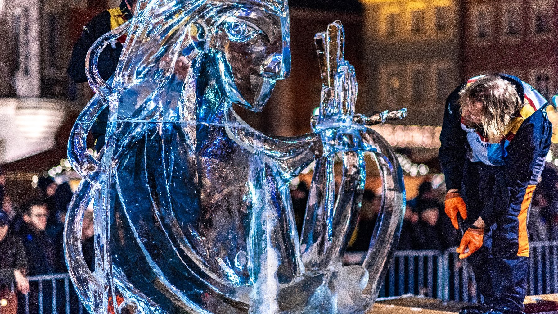 Zdjęcie przedstawia rzeźbę lodową i oglądającego ją mężczyznę.