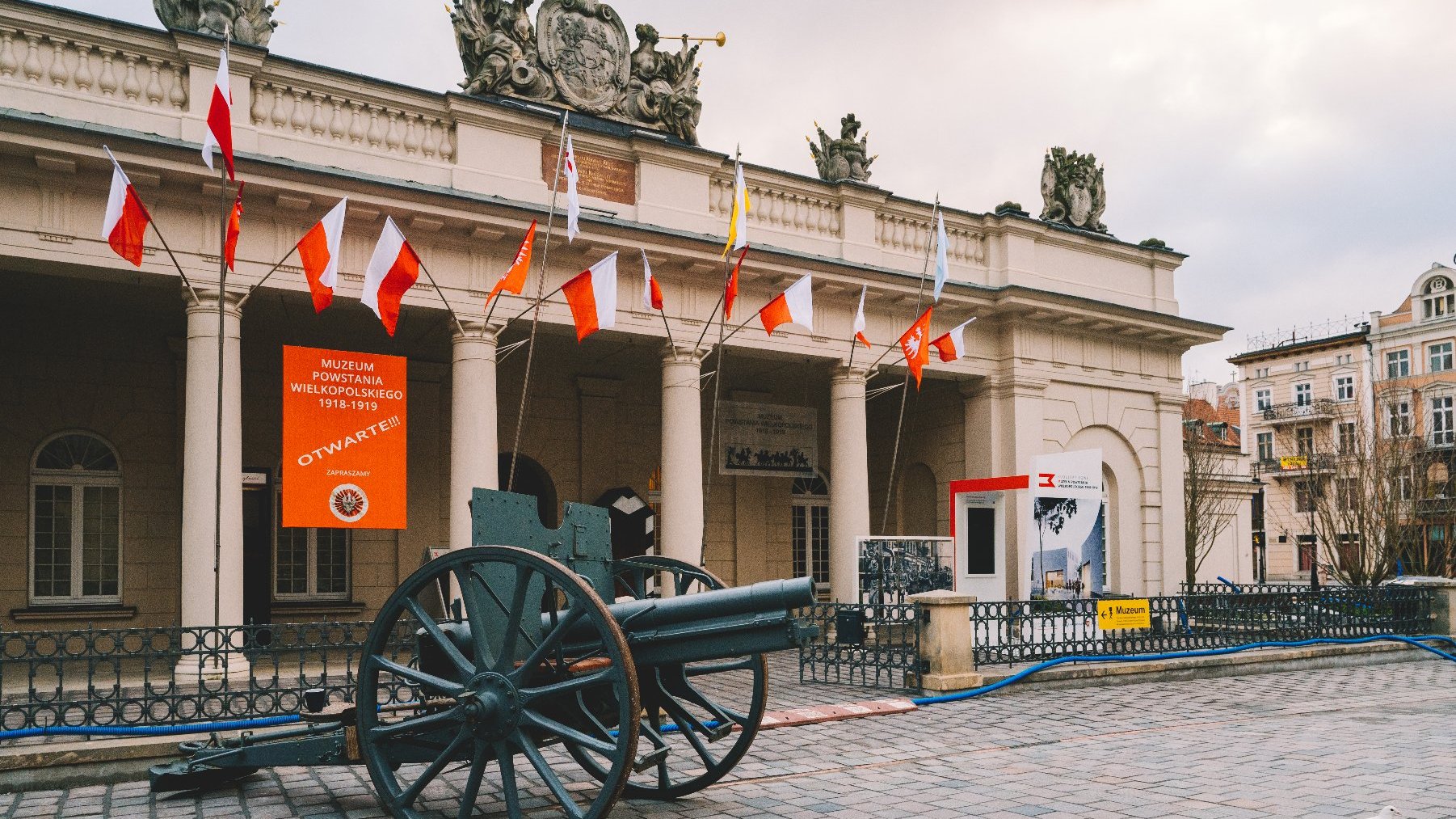 Na zdjęciu Muzeum Powstania Wielkopolskiego, przed nim armata, na nim wiszą flagi