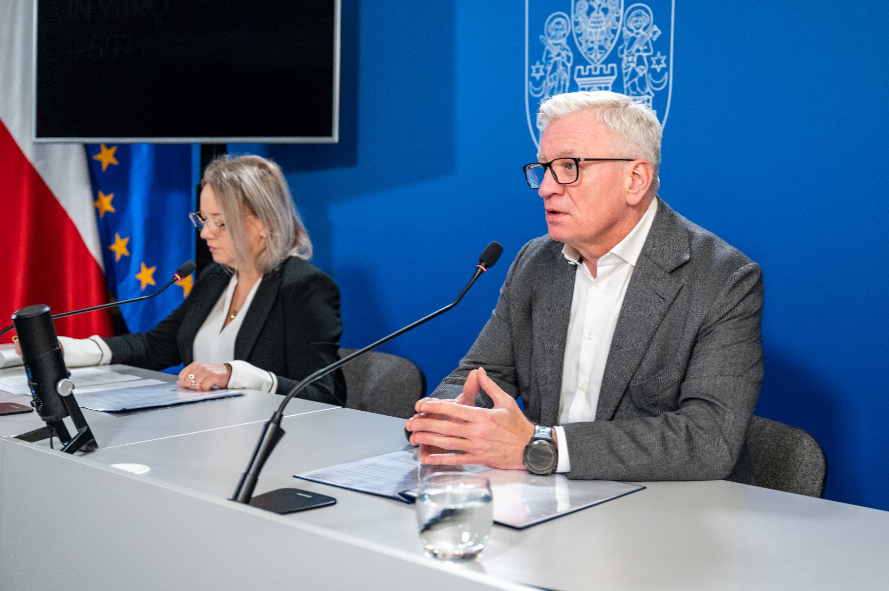 Na zdjęciu dwie osobyz a stołem konferencyjnym, w tym prezydent Poznania - grafika artykułu