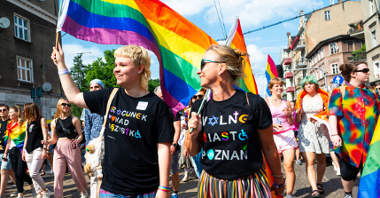 Na zdjęciu dwie osoby idące w Marszu Równości w miejskich koszulkach