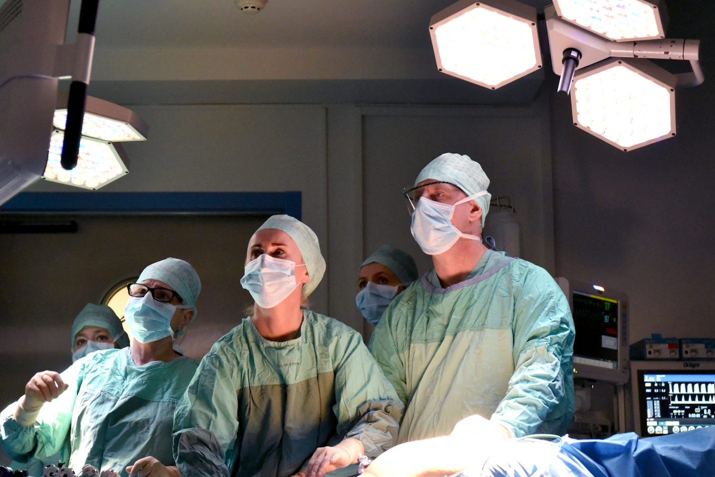 Na zdjęciu chirurdzy w sali operacyjnej, patrzą w ekran - grafika artykułu