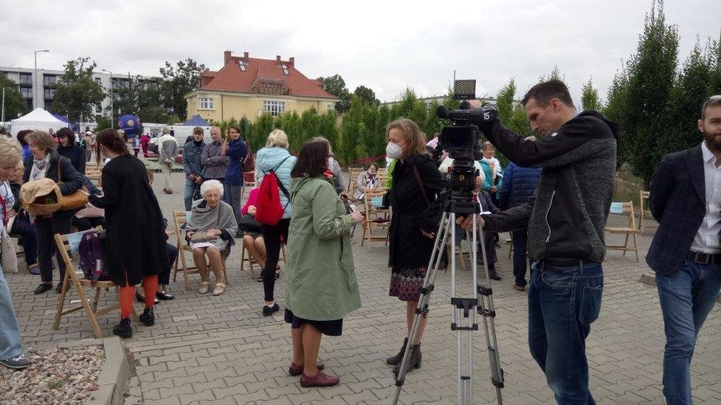 Ludzie w maseczkach rozmawiający na zewnątrz.