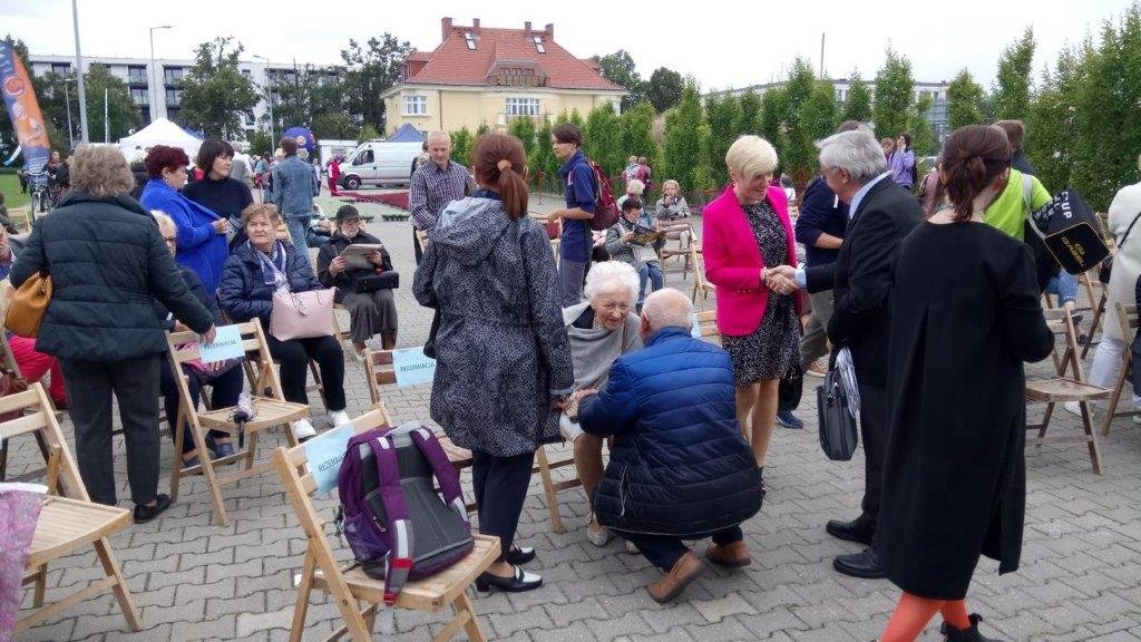 Ludzie w maseczkach rozmawiający na zewnątrz.