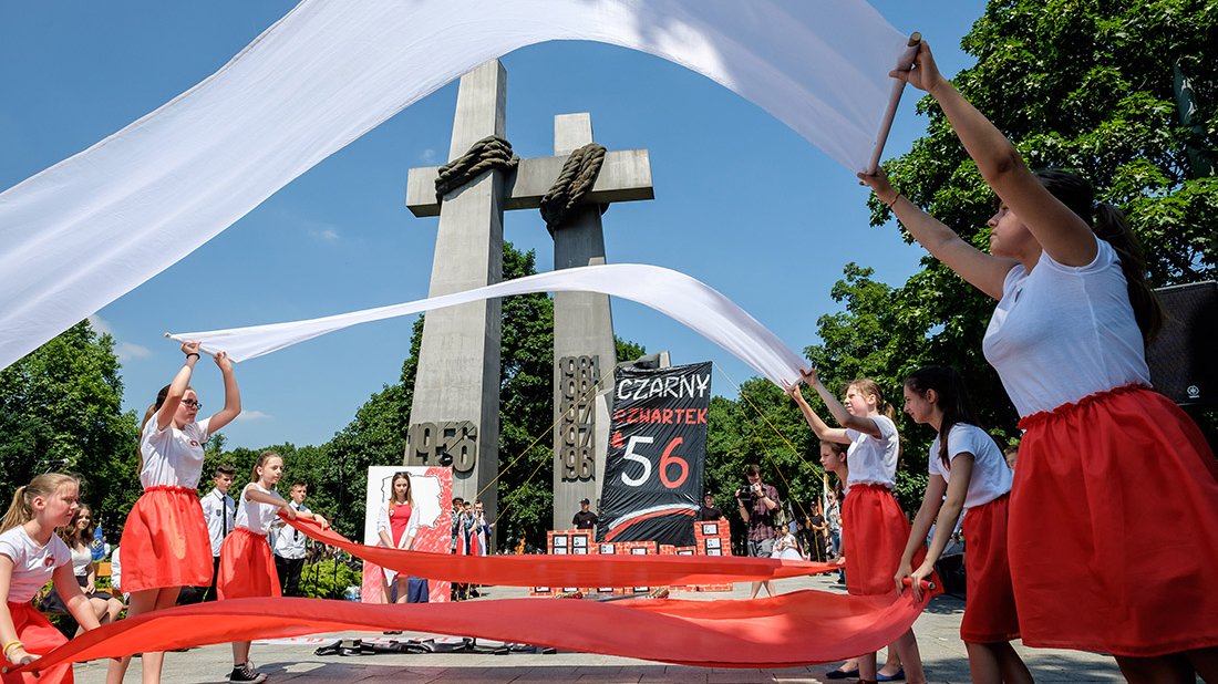 Dziewczynki falują biało-czerwonymi szarfami.