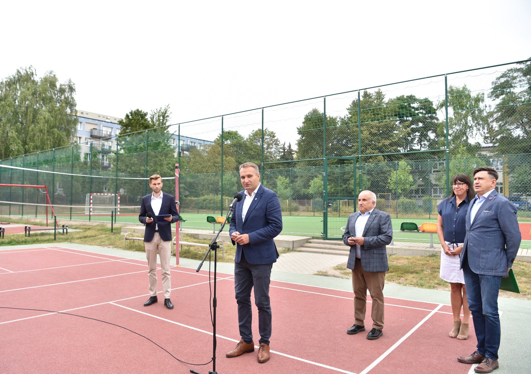 Zdjęcie przedstawia osoby biorące udział w konferencji prasowej na boisku. - grafika artykułu