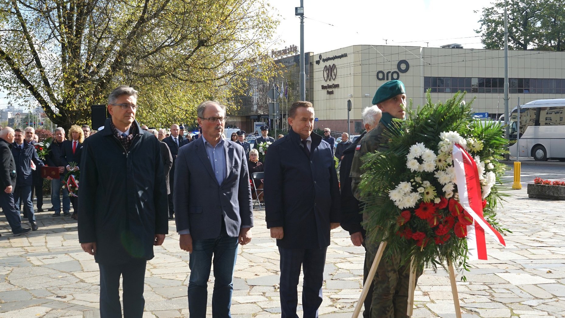 Na zdjęciu czterej mężczyźni składający wiązankę