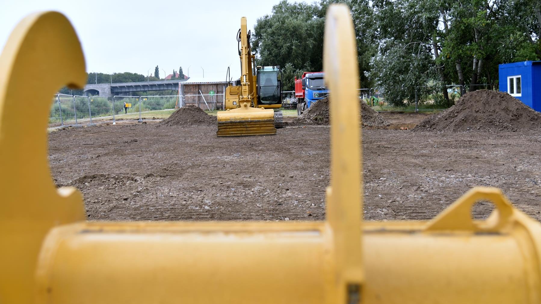 Zdjęcie przedstawia początek prac budowlanych. Widać na nim m.in. koparkę i hałdy ziemi