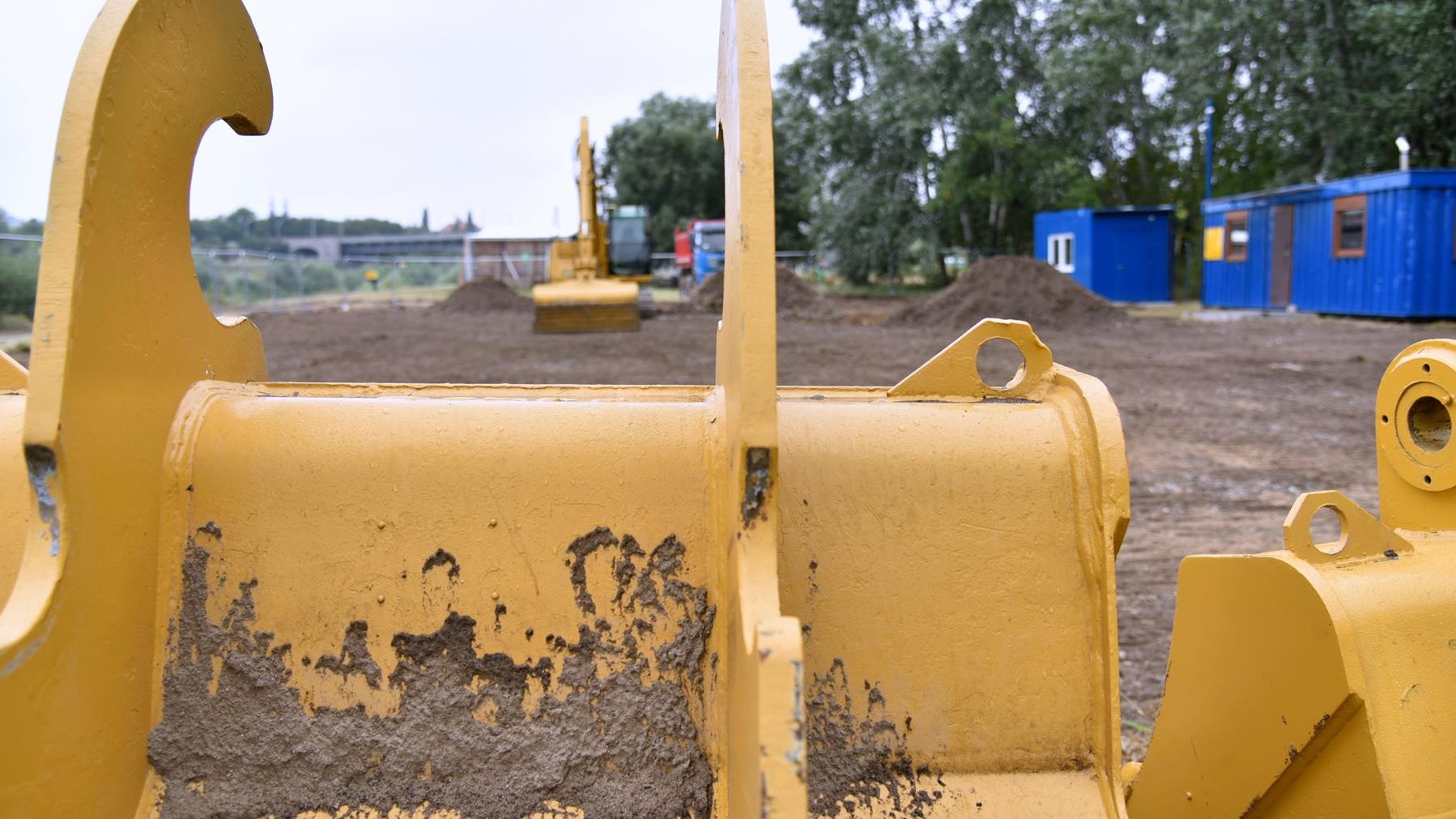 Zdjęcie przedstawia początek prac budowlanych. Widać na nim m.in. koparkę i hałdy ziemi