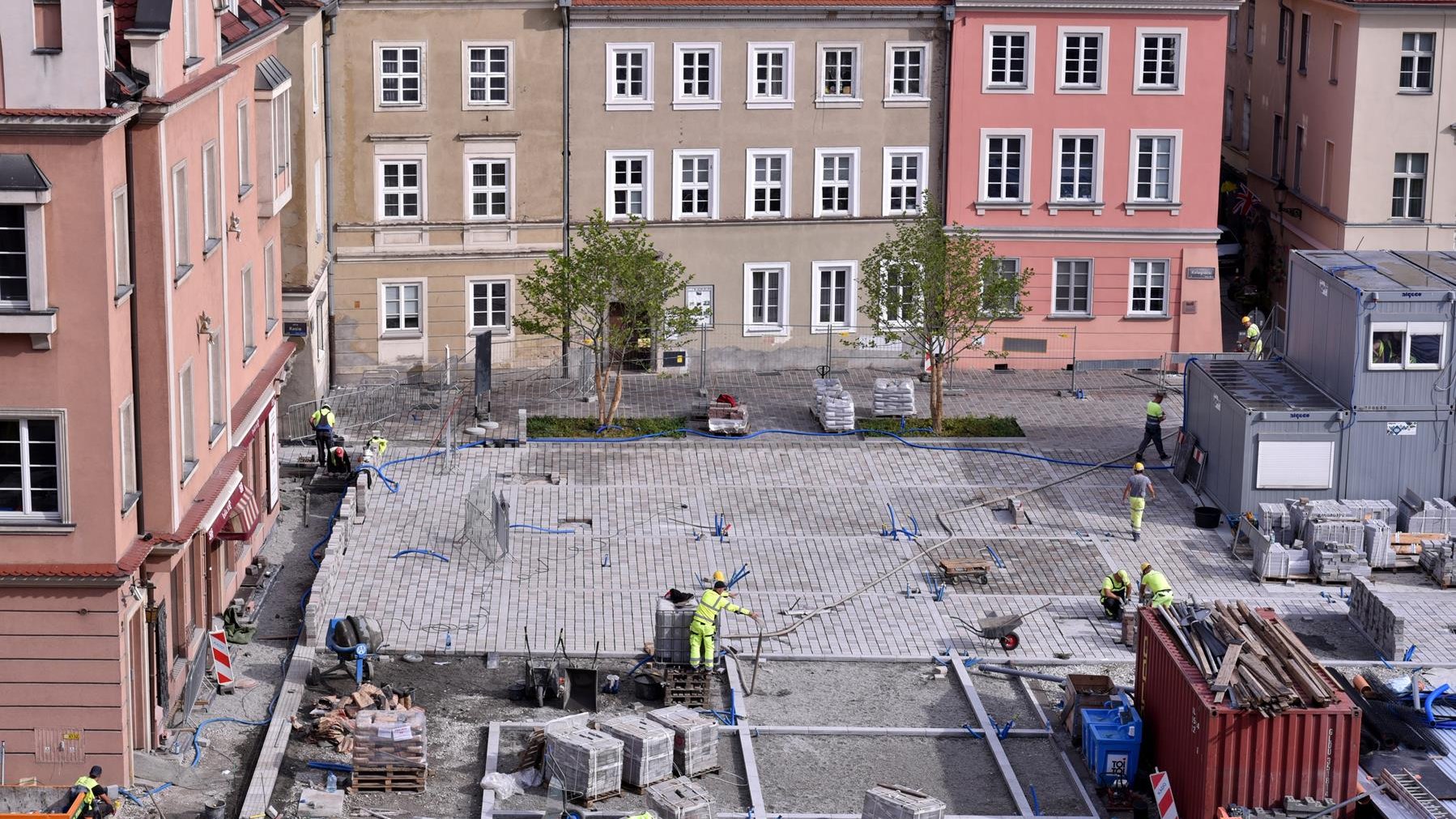 Widok z okiem urzedu miasta na przebudowywany plac Kolegiacki. Robotnicy układają kamienną nawierzchnię