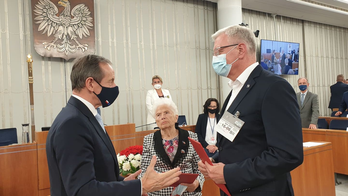 Na zdjęciu Tomasz Grodzki, Marszałek Senatu, wręczaa uchwałę Jackowi Jaśkowiakowi, obok Aleksandra Banasiak