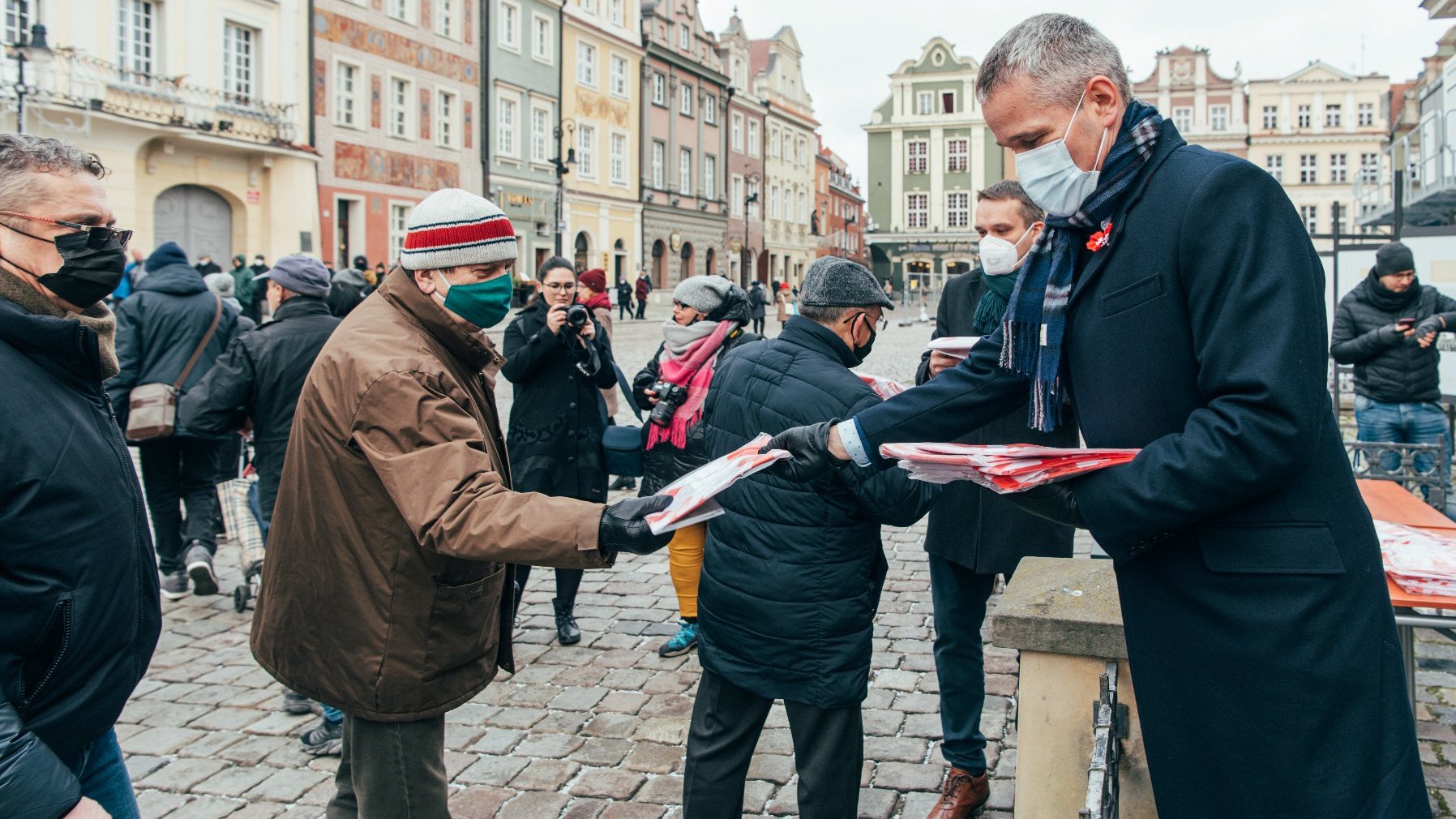 Galeria zdjęć przedstawia akcję rozdawania flag powstańczych poznaniakom na Starym Rynku.