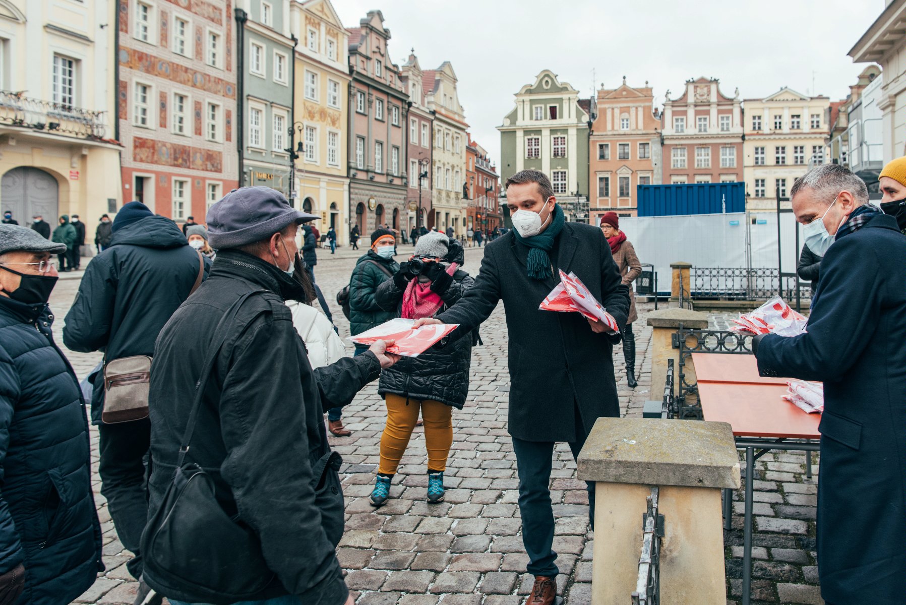 Galeria zdjęć przedstawia akcję rozdawania flag powstańczych poznaniakom na Starym Rynku. - grafika artykułu