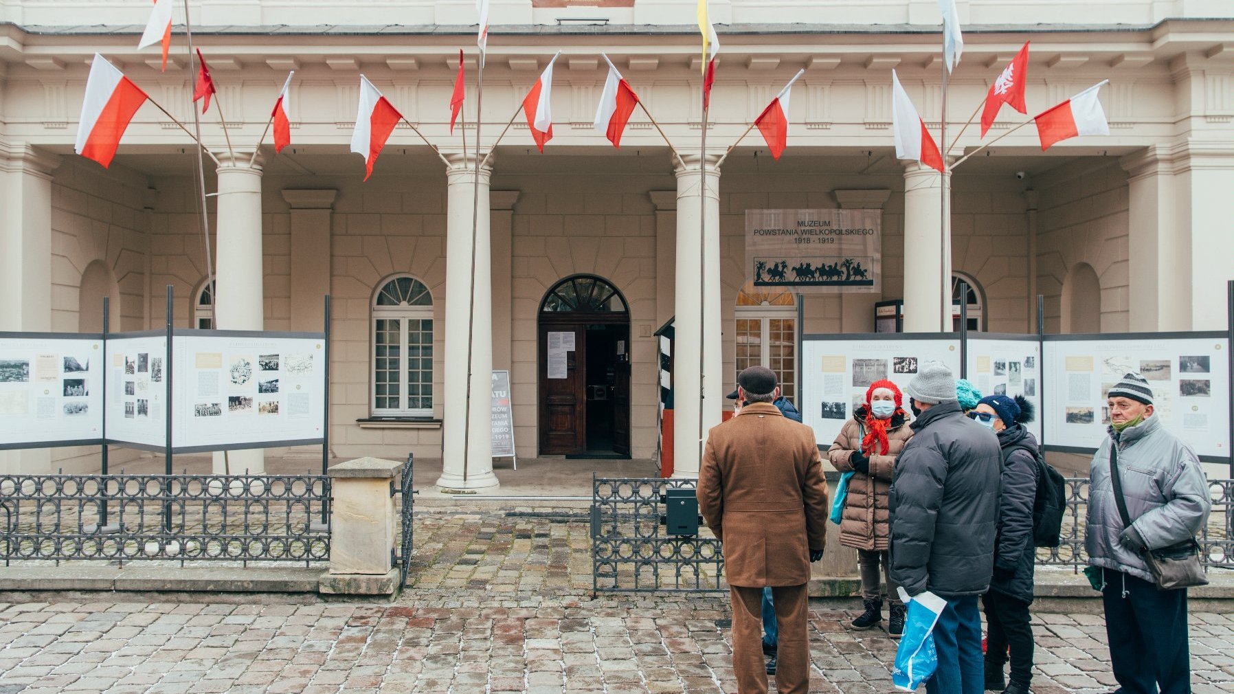 Galeria zdjęć przedstawia akcję rozdawania flag powstańczych poznaniakom na Starym Rynku.