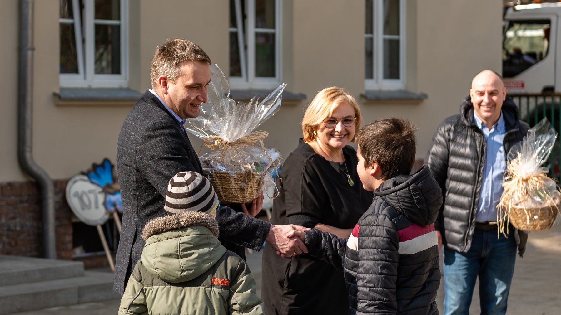 Mariusz Wiśniewski, zastępca prezydenta Poznania ściska dłoń uczniowi SP 107.