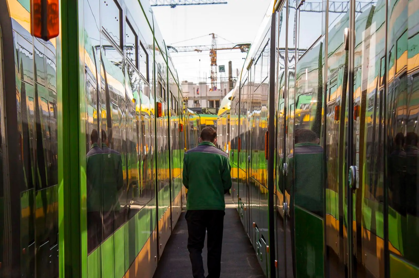 Motorniczy idący pomiędzy dwoma tramwajami - grafika artykułu