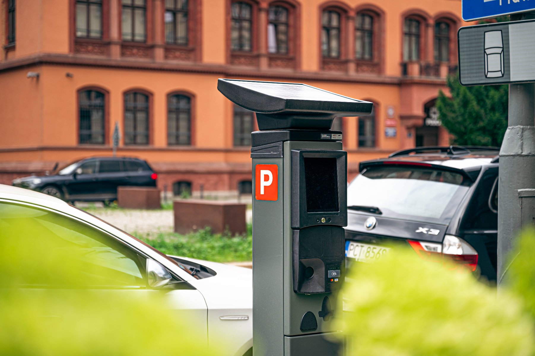 Na zdjęciu nowy parkomat, w tle samochody - grafika artykułu