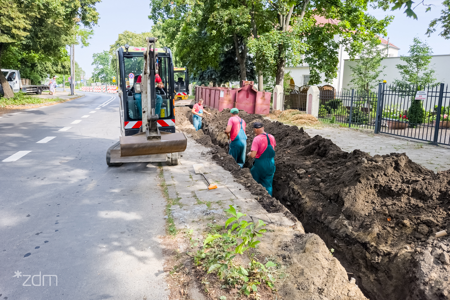 Na zdjęciu robotnicy pracujący przy chodniku - grafika artykułu