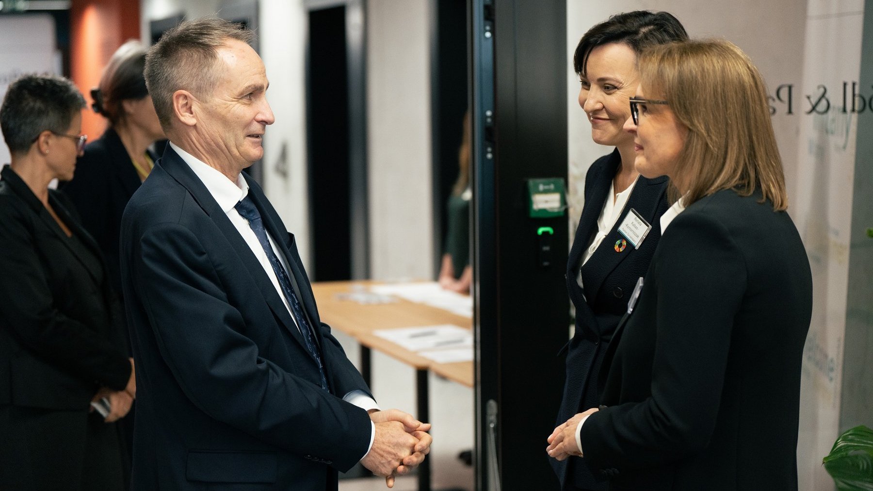 People attending the opening of the company. They talk smiling.