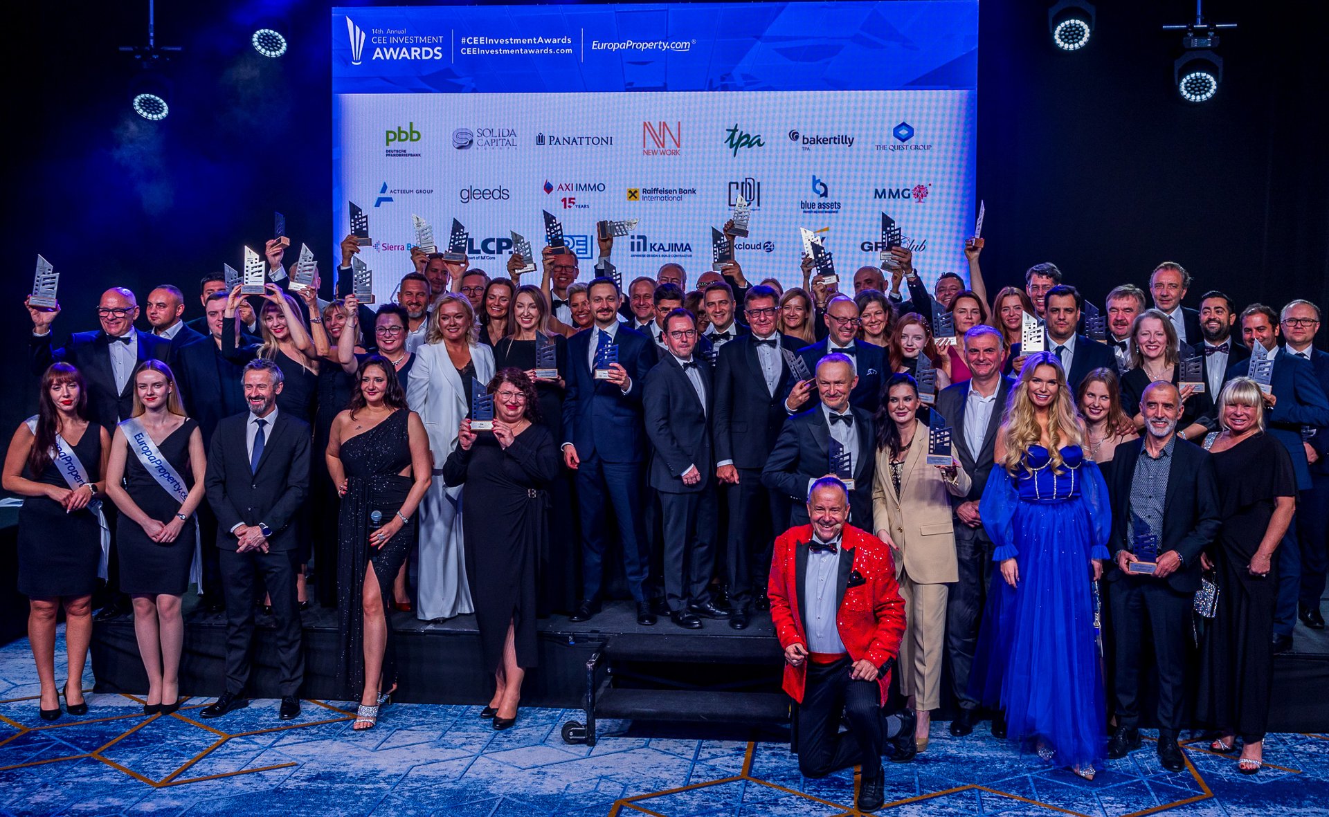 Agnieszka Susicka from the Investor Relations Department receiving the award. Together with her on stage, three men and a woman. All in evening dress. The logo of Poznań in the background. - grafika artykułu