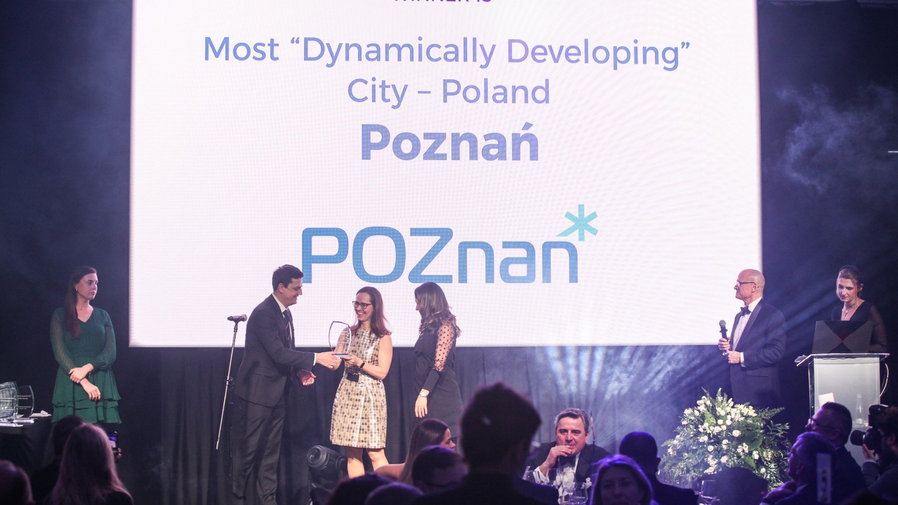 Representatives of the BOI receive an award on stage. In the background, a slide with the caption: "The most dynamically developing city in Poland".