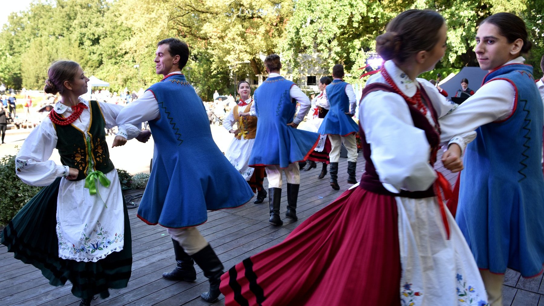 Zdjęcie przedstawia tańczących ludzi w tardycyjnych strojach.