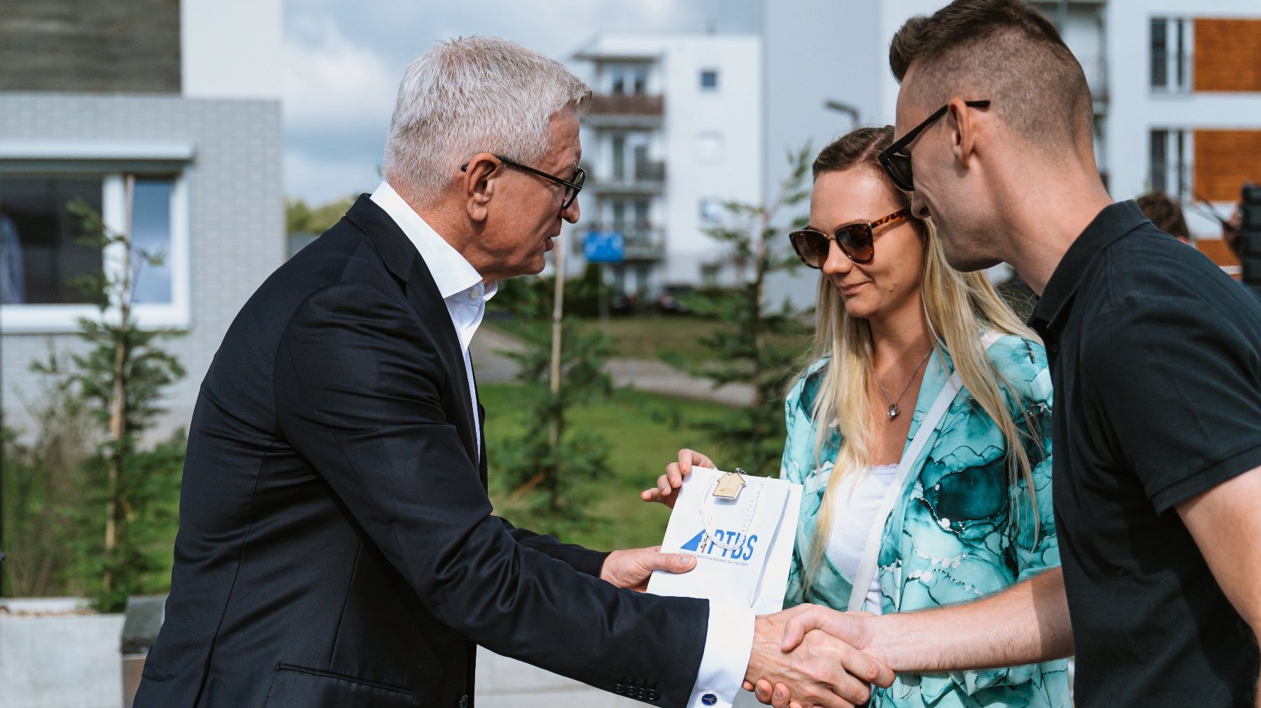 Na zdjeciu dwoje ludzi odbiera klucze od prezydenta Poznania