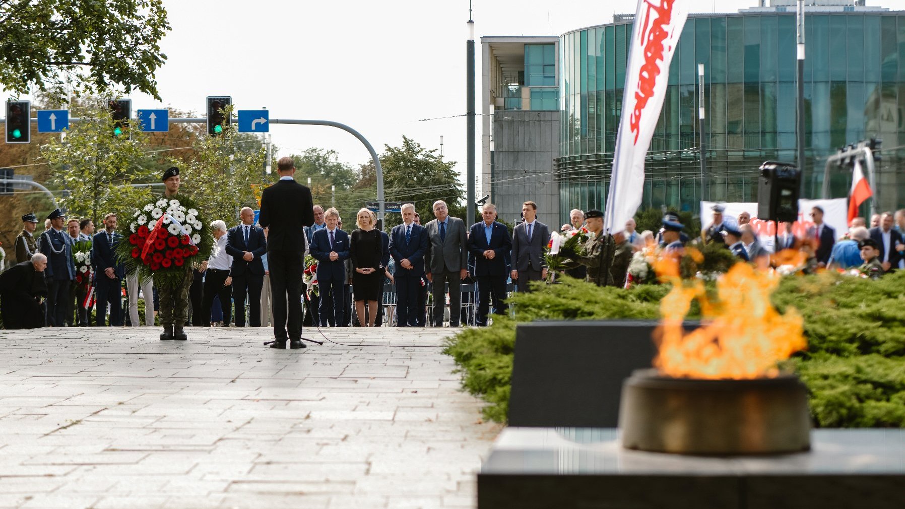 Zdjęcie przedstawia ludzi stojących na placu Mickiewicza.