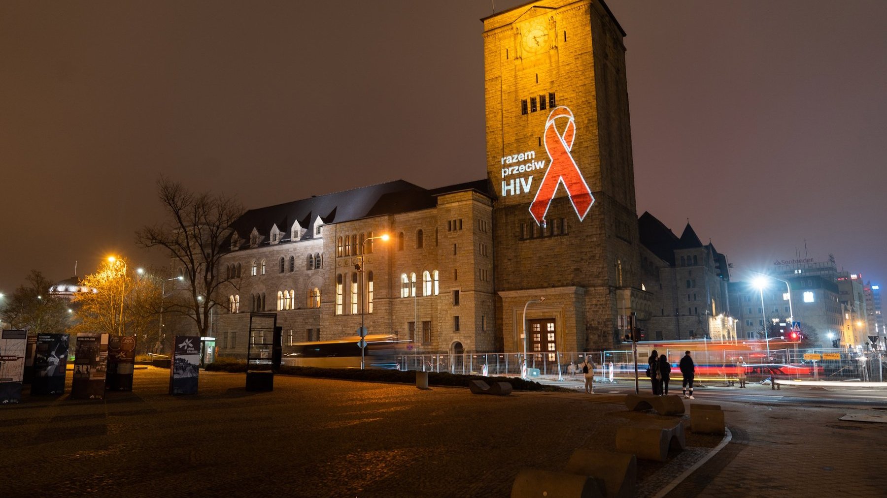 Zdjęcie przedstawia Centrum Kultury Zamek z podświetloną kokardą i napisem razem przeciw HIV.