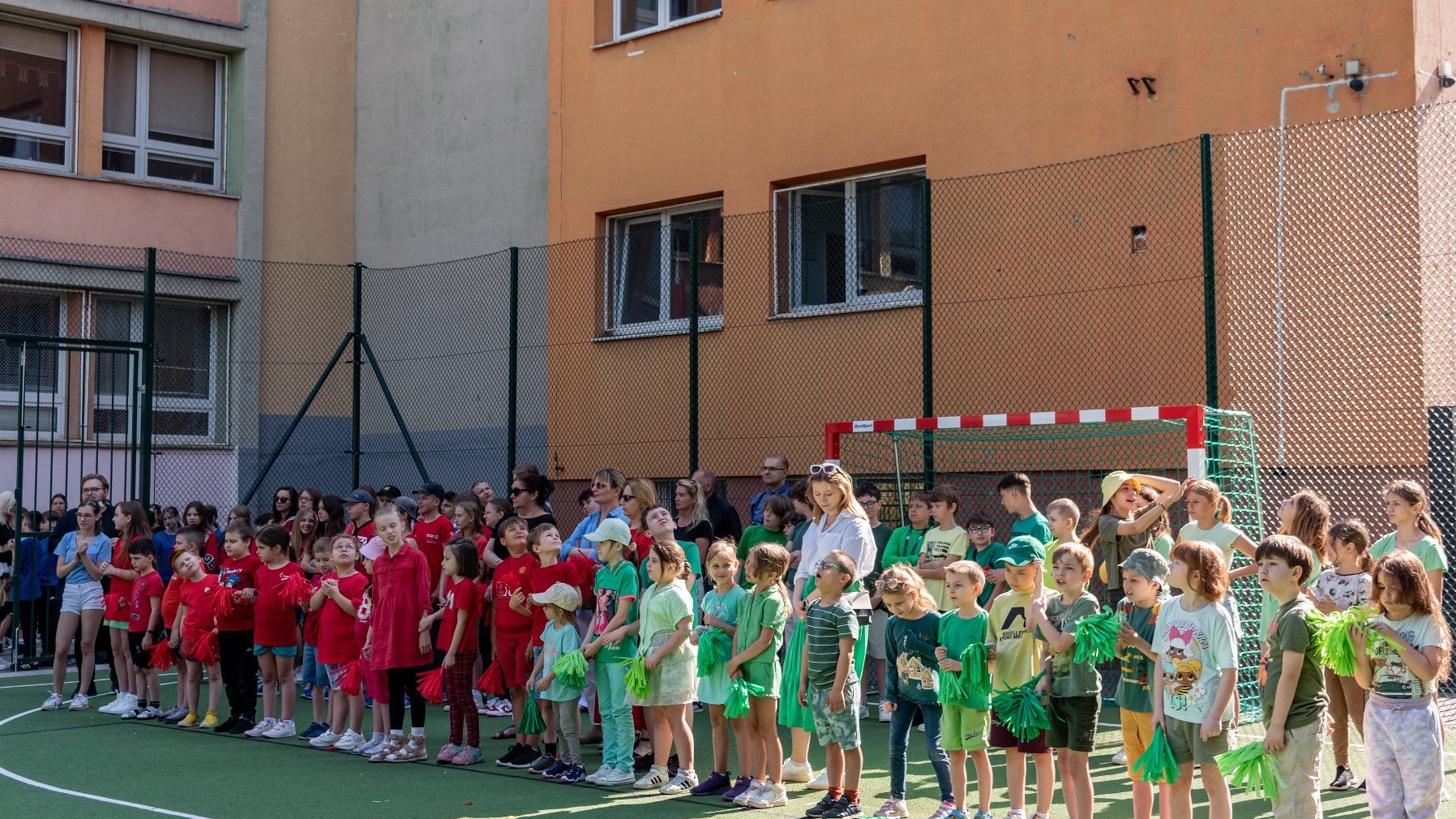 Zdjęcie przedstawia uczniów na boisku.