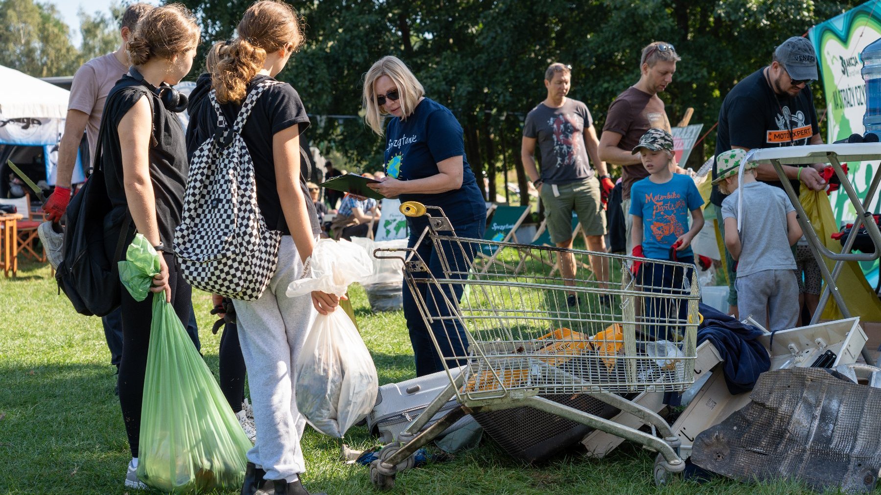 Zdjęcie przedstawia ludzi zbierających śmieci.