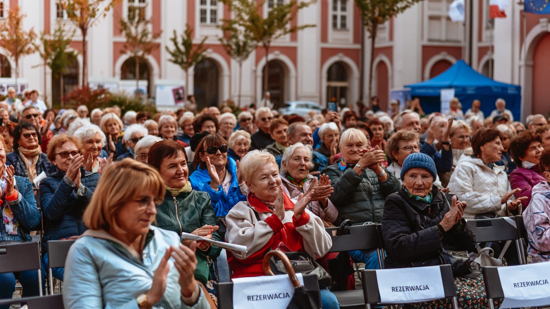 Na zdęciu seniorzy siedzący na dziedzincu urzędu