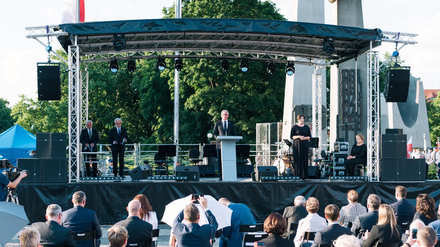 Jacek Jaśkowiak na scenie przy mównicy, w tle Pomnik Poznańskiego Czerwca