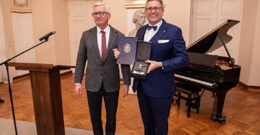 Na zdjęciu profesor trzymający Srebrną Pieczęć, obok prezydent Poznania