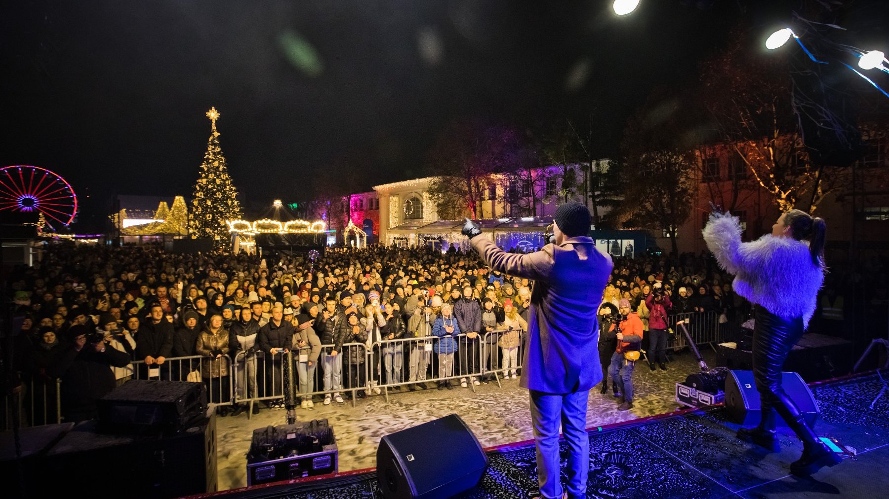 Zdjęcie przedstawia kobietę i mężczyznę na scenie oraz tłum ludzi za barierką.