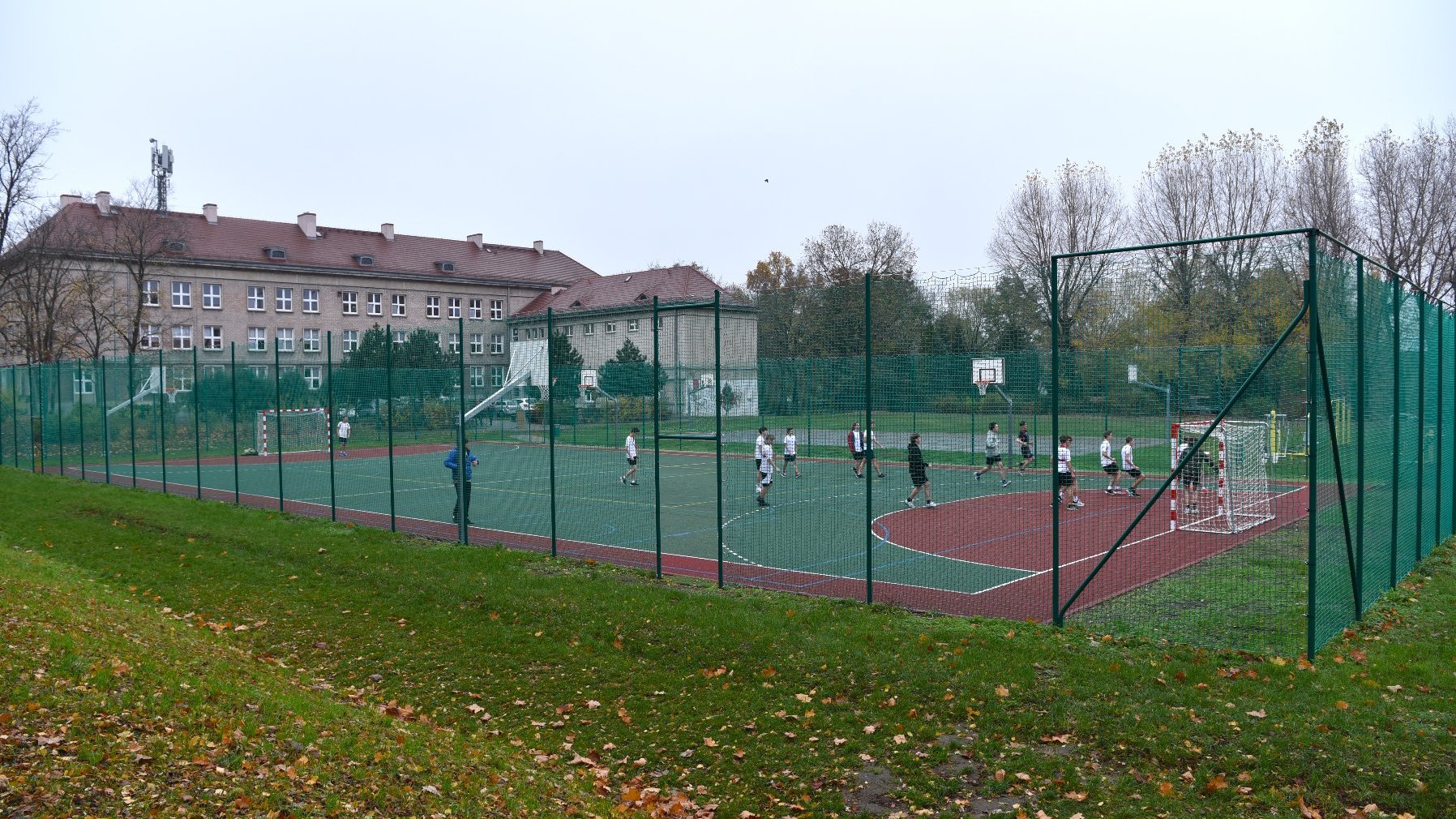 Zdjęcie przedstawia uczniów na boisku.