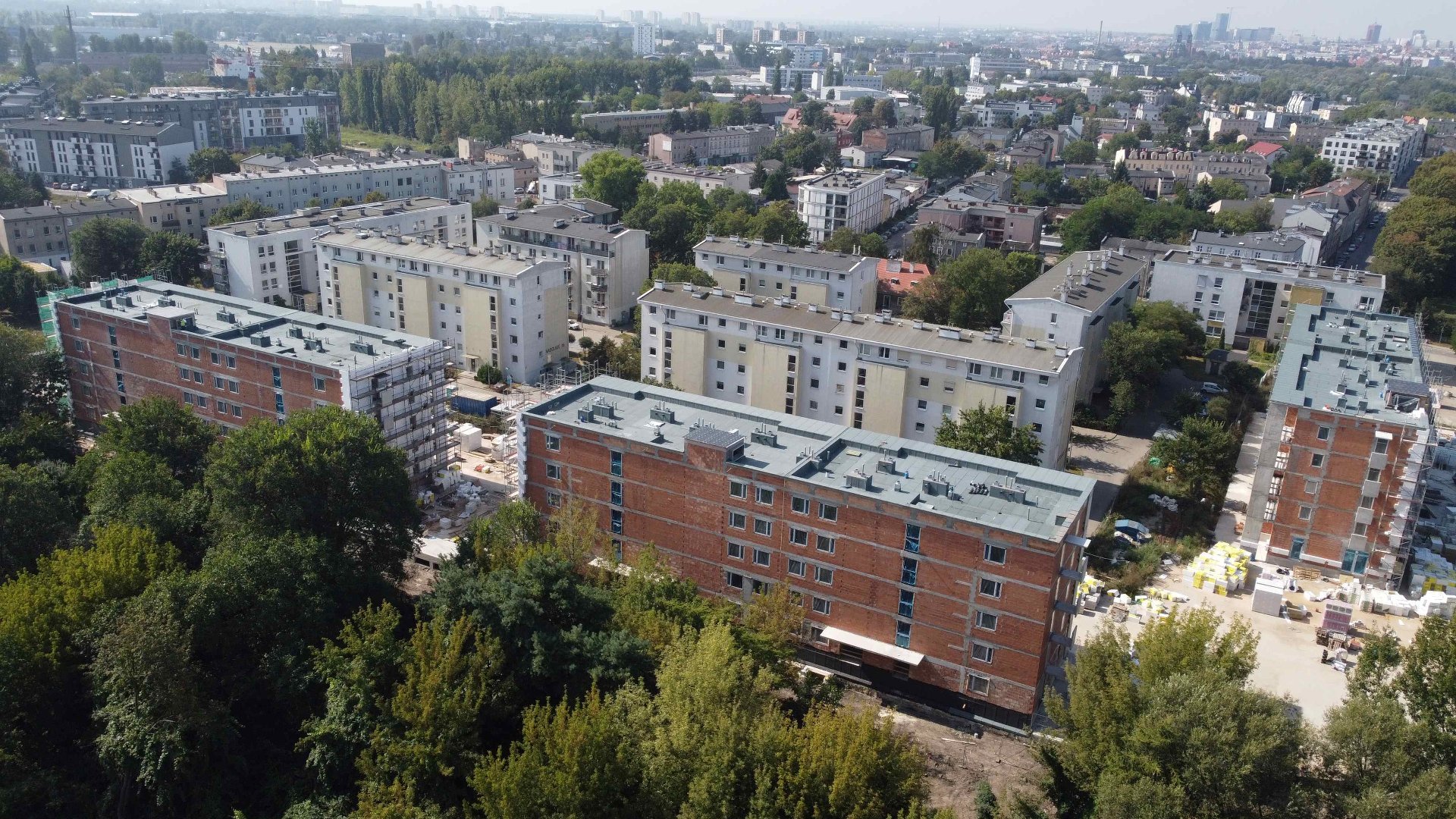 Zdjęcie przedstawia powstające budynki oraz inne zabudowania z lotu ptaka.