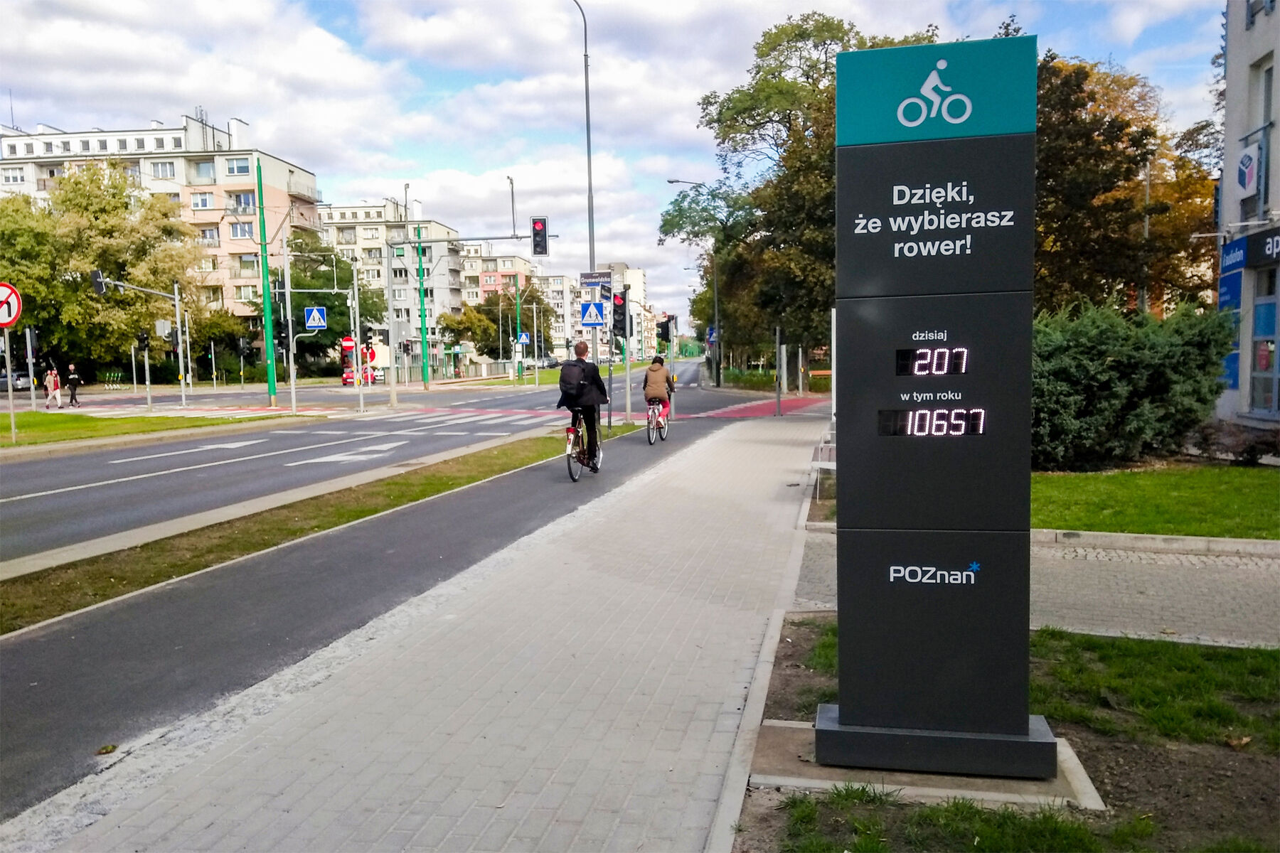 Licznik rowerowy przy ul. Grunwaldzkiej, na drodze rowerowej 2 rowery, po obu stronach bloki. - grafika artykułu