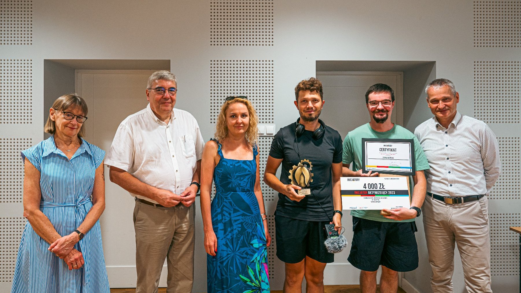 Grupowe zdjęcie laureatów i osób wręczających nagrody.