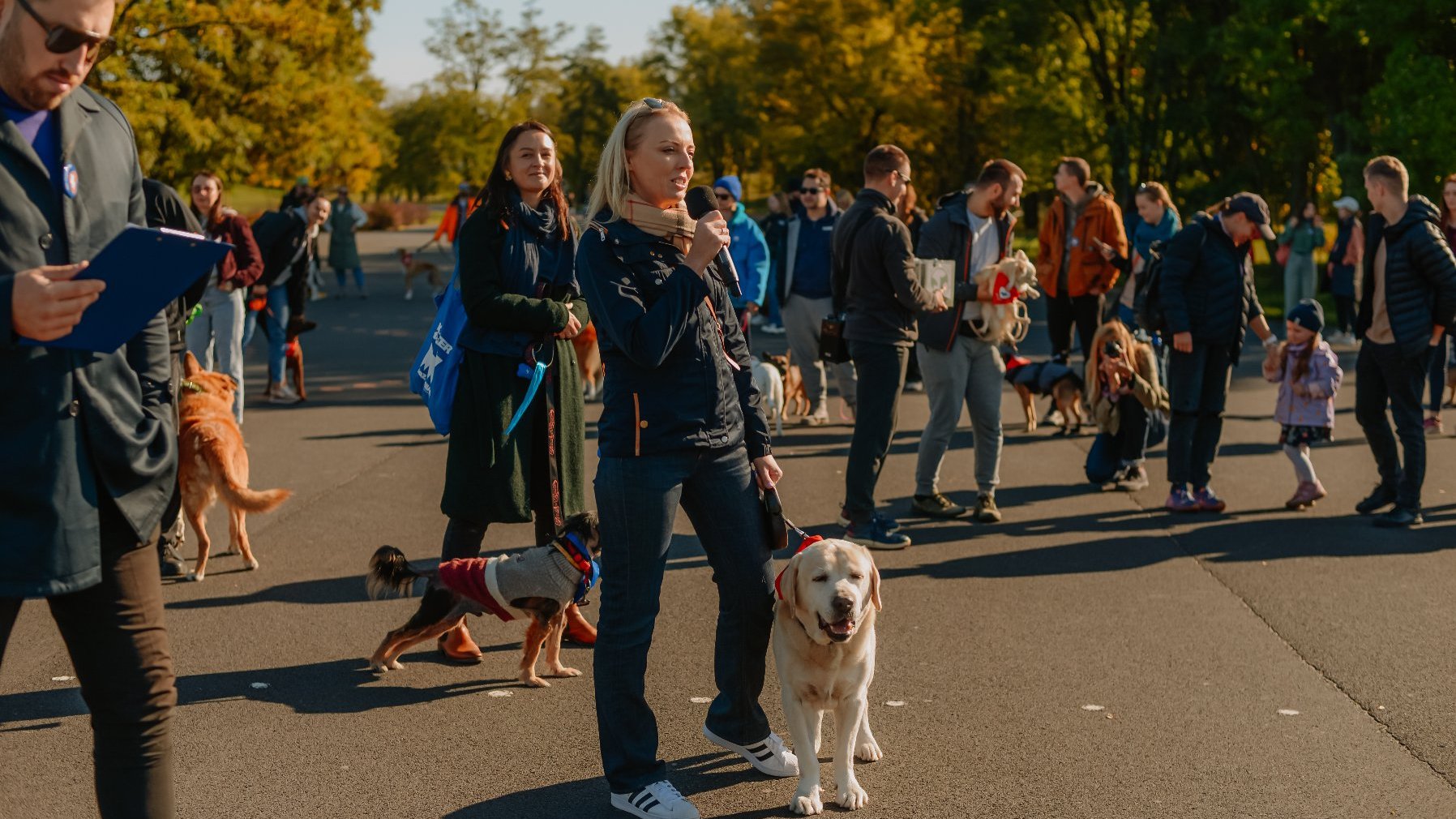 Zdjęcie przedstawia ludzi z psami.