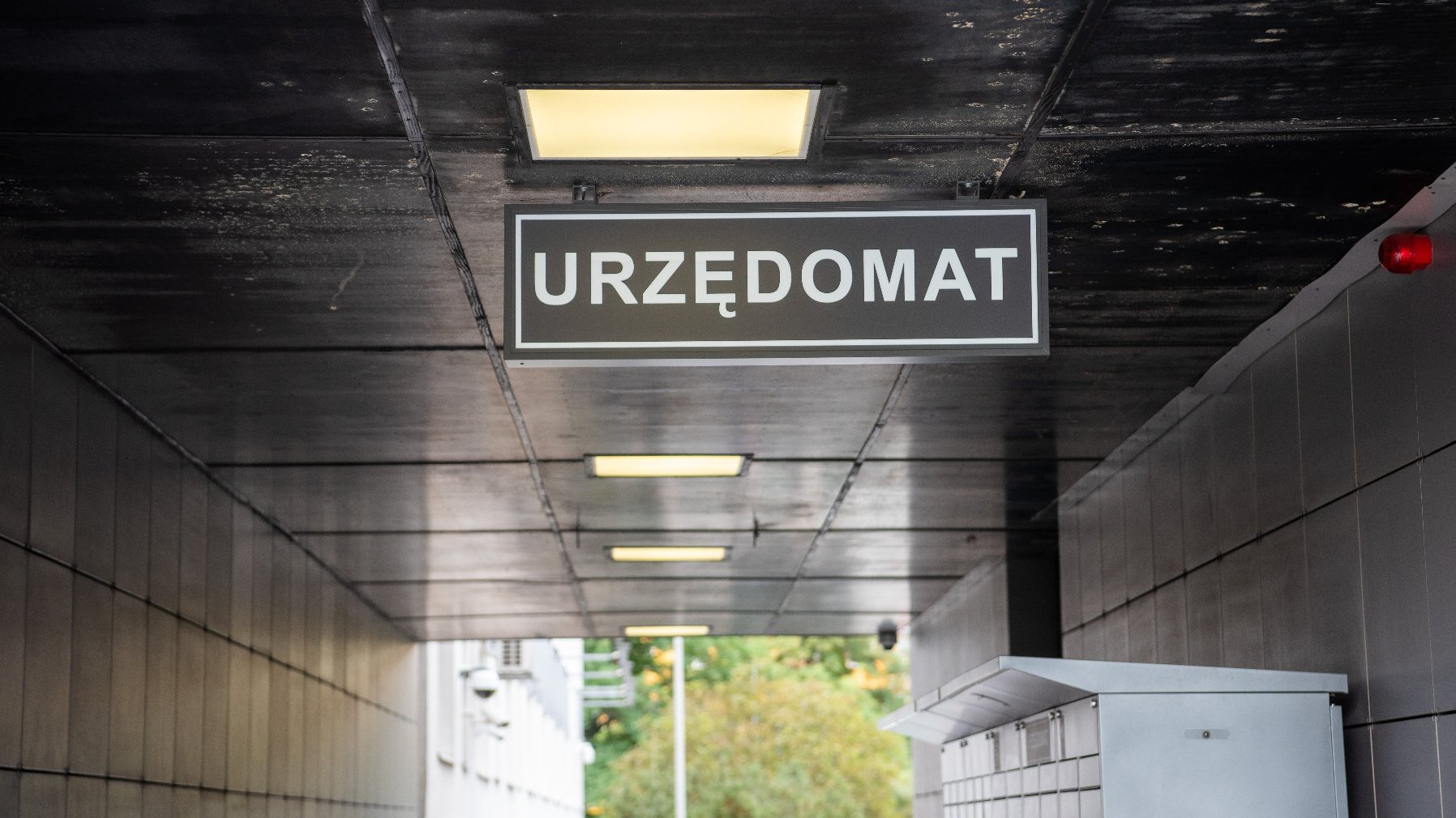 Na zdjęciu tablica z napisem: urzędomat, pod nią maszyna