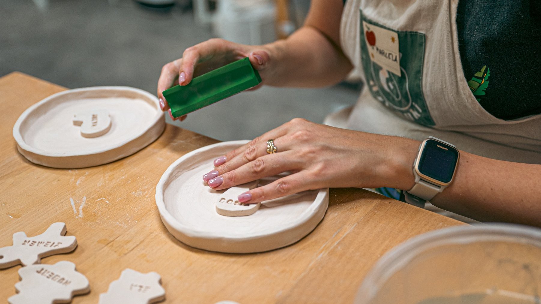 Zdjęcie przedstawia ręcę kobiety robiącej ozdoby ceramiczne.