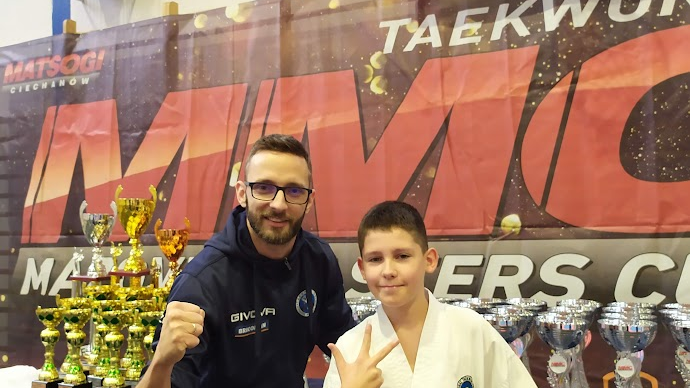 Zawodnicy PSKT na zawodach Mazovia Masters Cup - trener i zawodnik stoją na tle ścianki