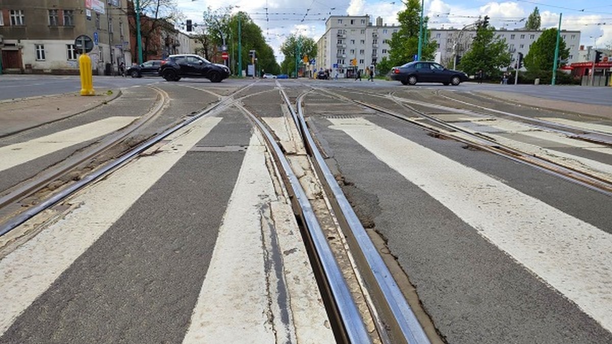 skrzyżowanie ulic i torowisk tramwajowych, widoczne samochody budynki przy skrzyżowaniu - grafika artykułu