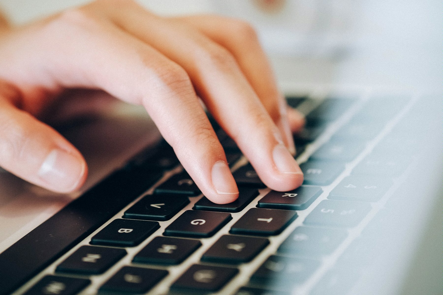 Zdjęcie przedstawia rękę piszącą na klawiaturze laptopa. - grafika artykułu