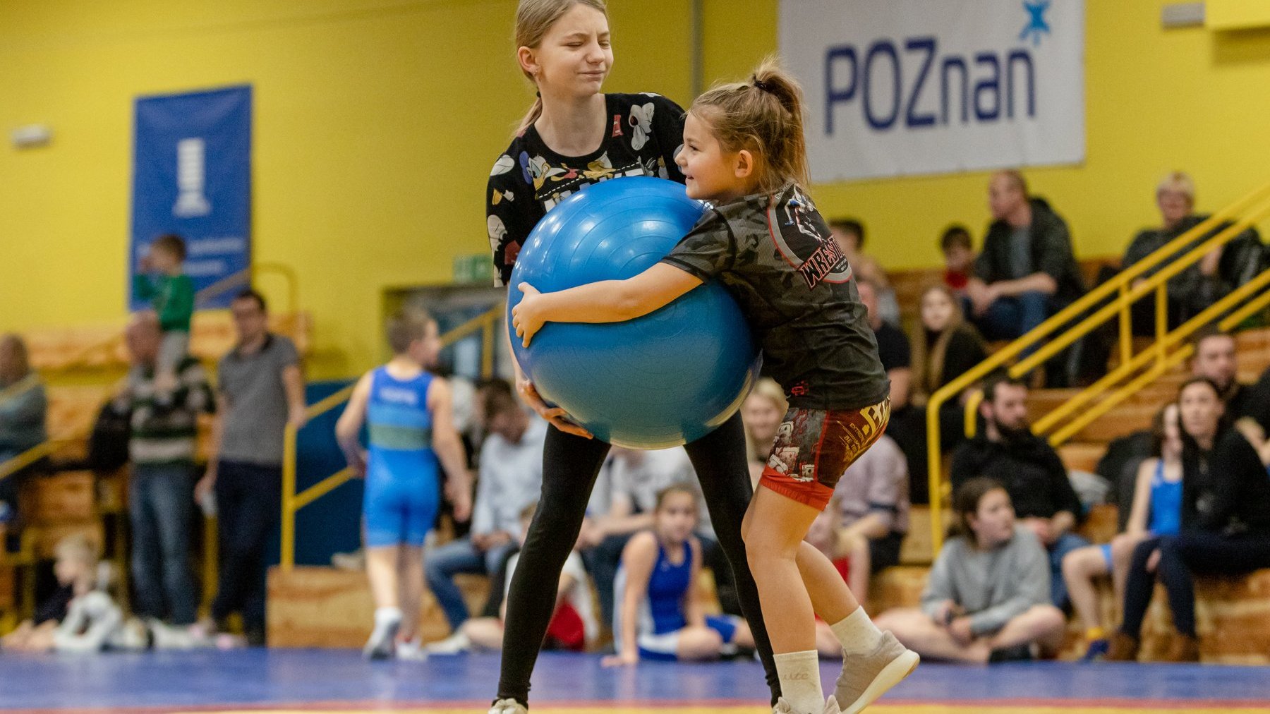 dwie dziewczyny podczas walki o dużą niebieską piłkę