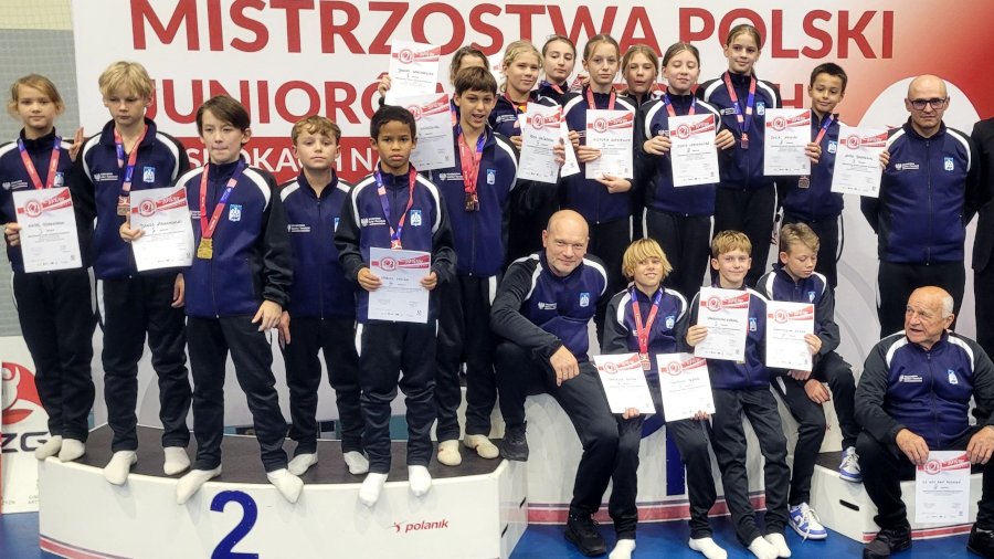 Reprezentacja AZS AWF Poznań na zawodach MPJM w gimnastyce - zawodniczki i zawodnicy na podium z dyplomami i medalami