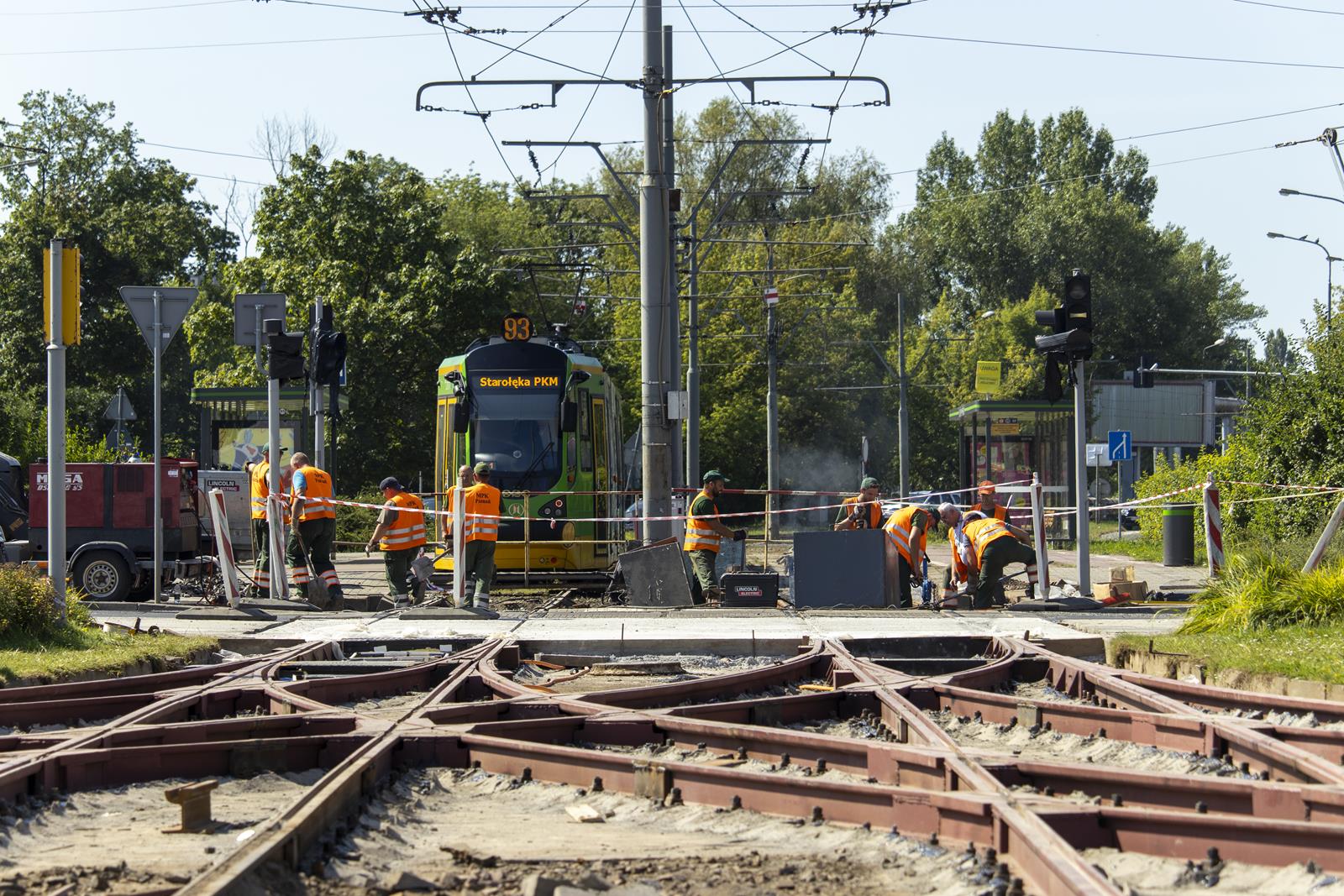 Nowo ułożone torowisko, w tle robotnicy i tramwaj - grafika artykułu