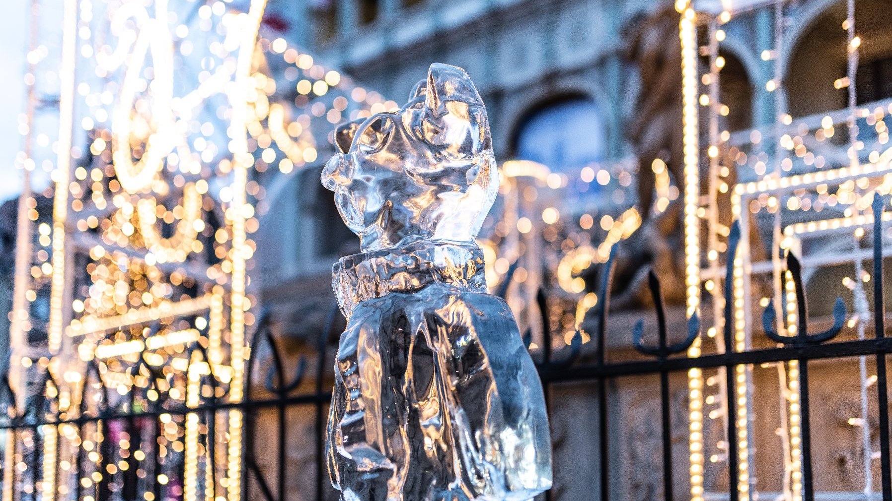 Zdjęcie przedstawia rzeźbę lodową i iluminacje świąteczne.