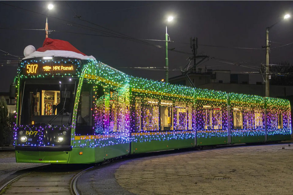 Na zdjeciu podświetlony tramwaj w czerwonej czapce Mikołaja. - grafika artykułu