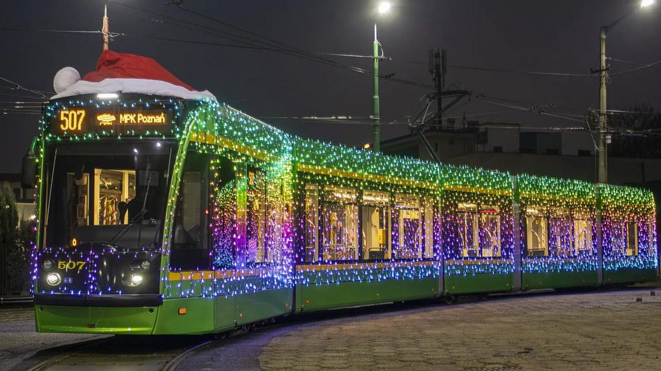 Na zdjeciu podświetlony tramwaj w czerwonej czapce Mikołaja.